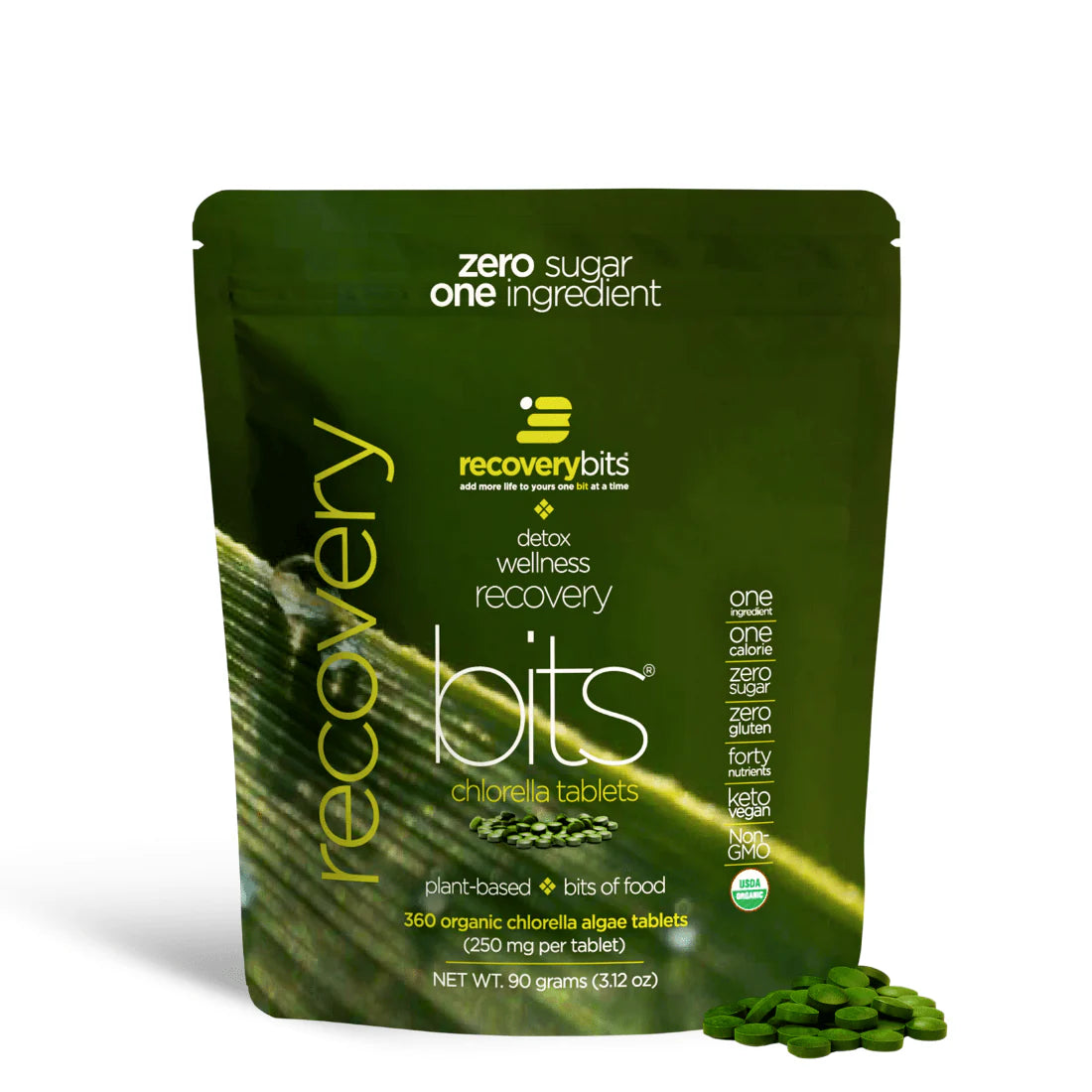 A small green pouch labeled RECOVERYbits Chlorella with a brief description of the product's benefits. The pouch also displays the text 'Zero Sugar One Ingredient' and mentions that it contains 40 organic chlorella algae tablets.