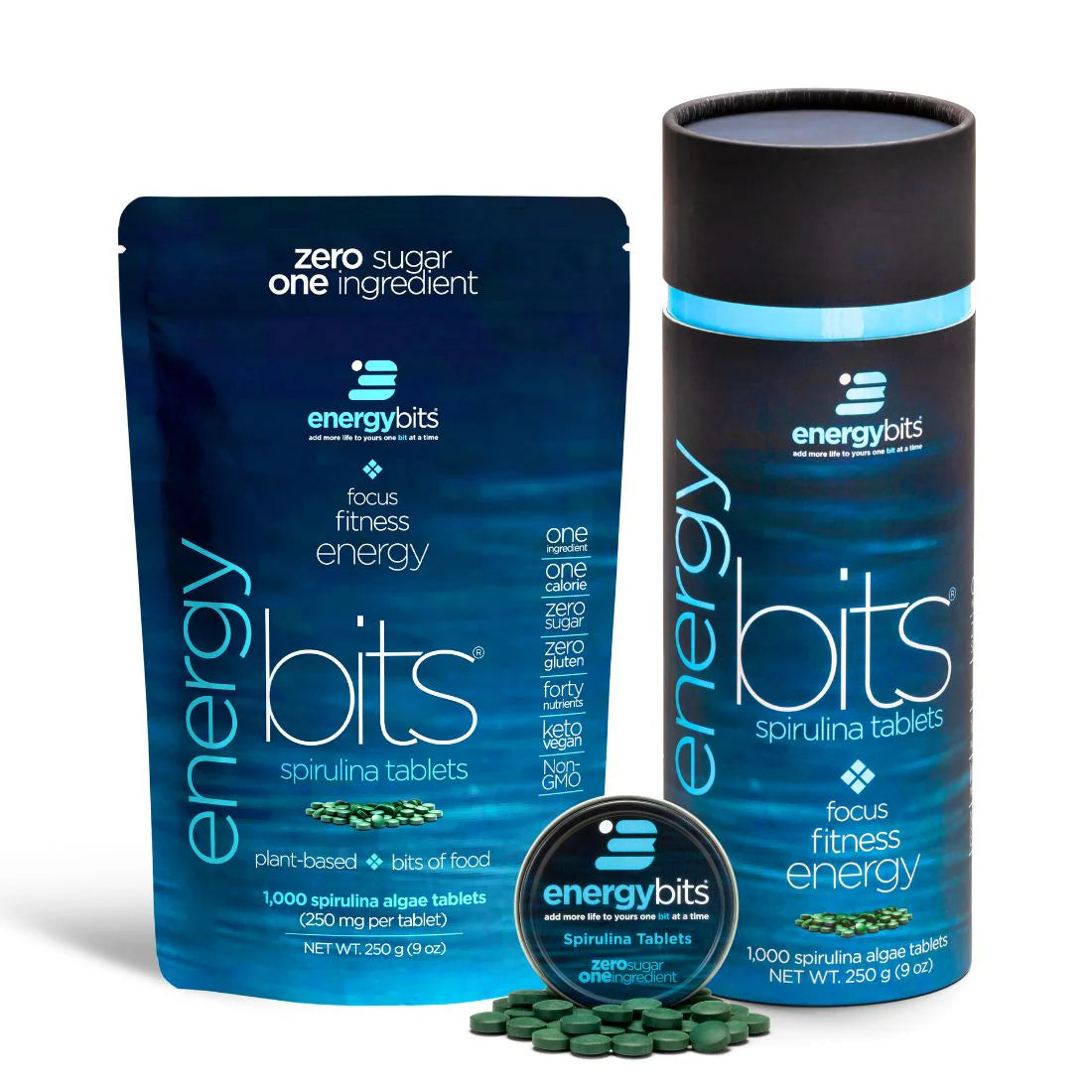 A canister and a pouch of ENERGYbits Spirulina tablets, with the product's benefits highlighted. The canister is black with blue accents, and the pouch is blue with text detailing the product's use for energy and fitness.