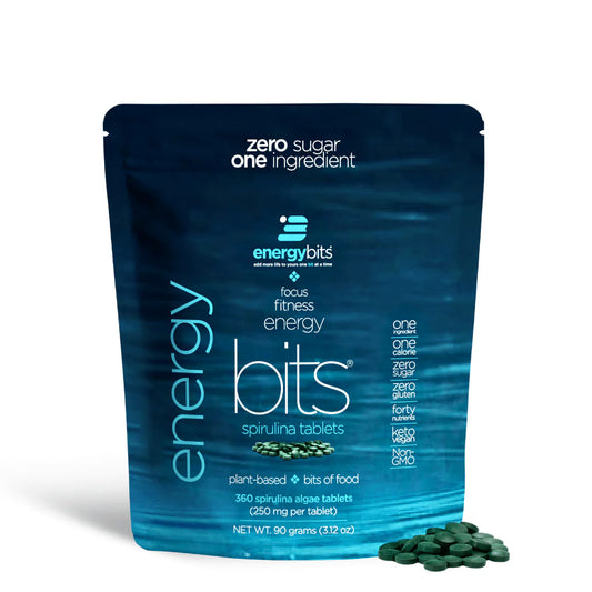 A small blue bag of ENERGYbits Spirulina, with the product's name and key features such as 'Zero Sugar', '100% Plant-Based', and '3000 mg. Chlorella' displayed on the packaging.