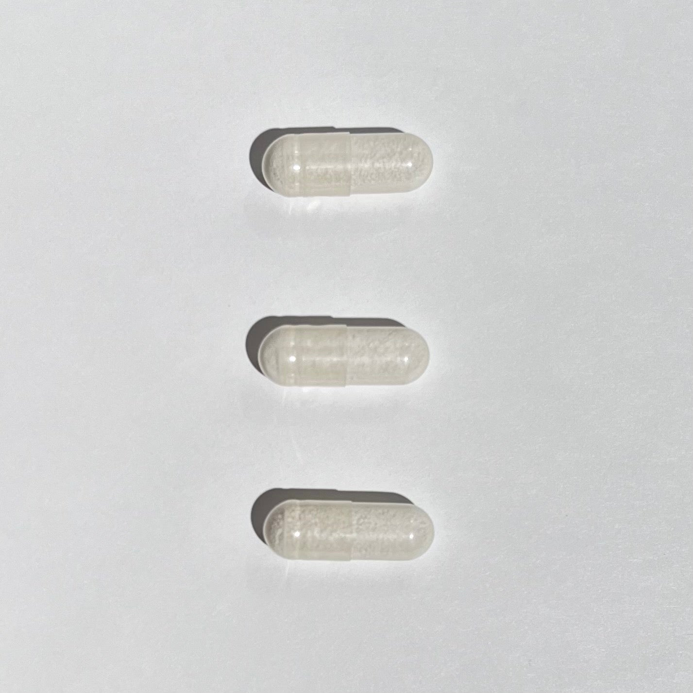 Three transparent capsules on a white background
