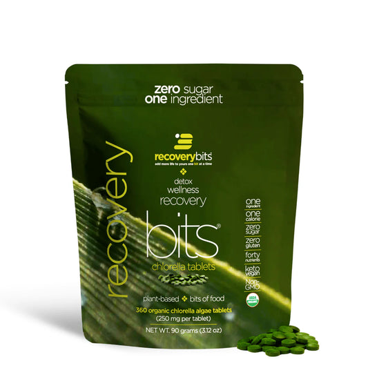 A small green pouch labeled RECOVERYbits Chlorella with a brief description of the product's benefits. The pouch also displays the text 'Zero Sugar One Ingredient' and mentions that it contains 40 organic chlorella algae tablets.